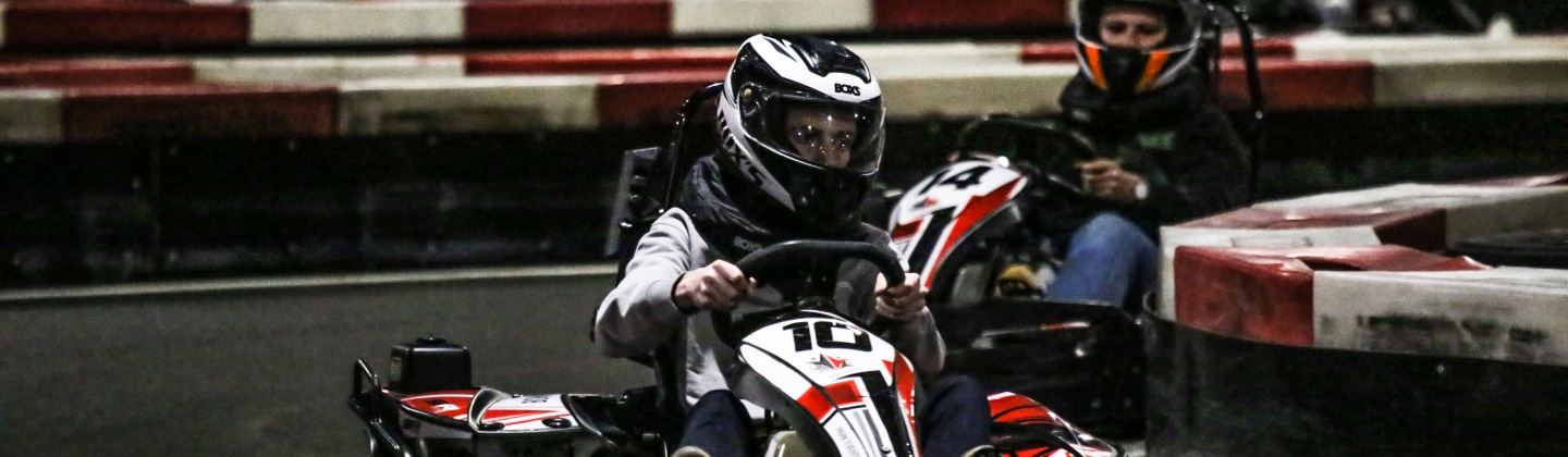 Un pilote casqué au volant d'un kart chez Park Events